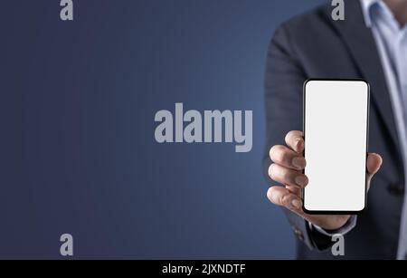 mockup cell phone. businessman in suit showing blank white mobile phone screen in horizontal position on blue background. mobile app advertising Stock Photo