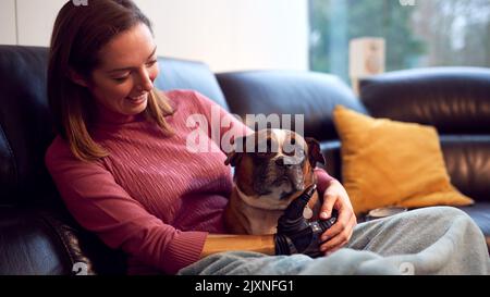 Woman With Prosthetic Arm And Hand At Home With Pet Dog Stock Photo