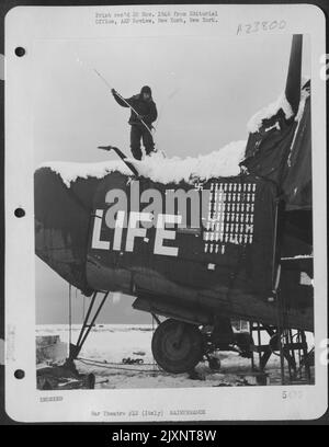 Ground Crewman Cleans Snow From The Consolidated B-24 Liberator 'Life' At A 15Th Af Base In Italy. Stock Photo