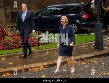 New Prime Minister, Liz Truss, walks up Downing Street with her husband, Hugh O'Leary. They stop and wave at the door of Number 10 before her speech. Stock Photo