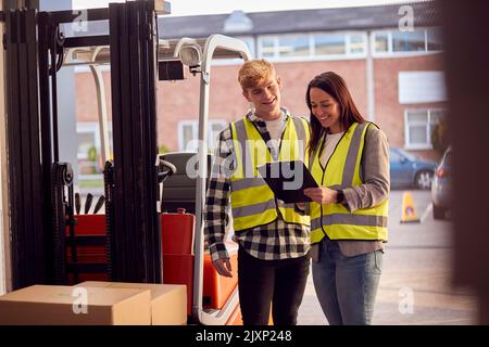Supervisor Teaching Intern To Operate Fork Lift Truck In Modern Warehouse Stock Photo