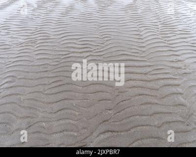 Relief on a sandy beach, full frame. Wavy pattern. Stock Photo