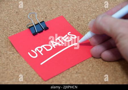 Update text on red notepad with wooden cover background. Update concept. Stock Photo