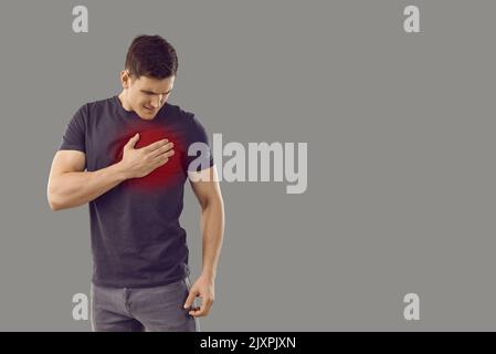 Man isolated on copy space background suffering from heart pain and touching his chest Stock Photo