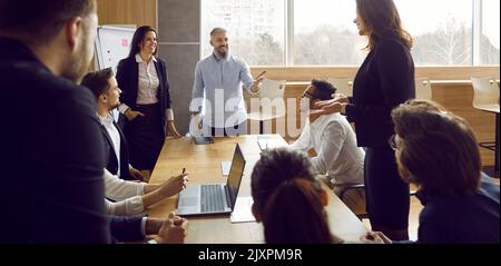 Business team during morning briefing in office discussing ideas and exchanging interesting ideas. Stock Photo