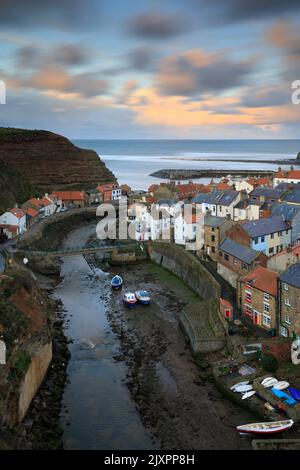 Clouds over the village of Staithes on the North Yorkshire Coast illuminated by the setting sun. Stock Photo