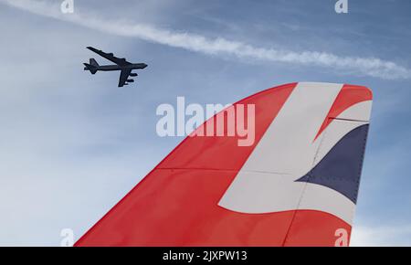 Boeing B-52 Stratofortress Long Range Bomber Flying Behind The Union Jack Tail Of A Red Arrow Hawk T1 Aerobatic Display Jet, Bournemouth UK Stock Photo