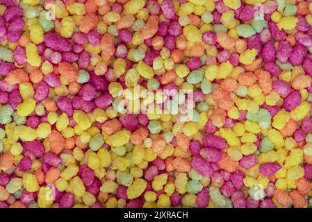 Close up macro photograph of bright multicolored sugar coated puffed maize and rice candy abstract background shot from above Stock Photo