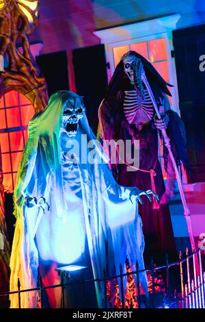 A scary clown decorations in a haunted house for Halloween swinging on a swing Stock Photo