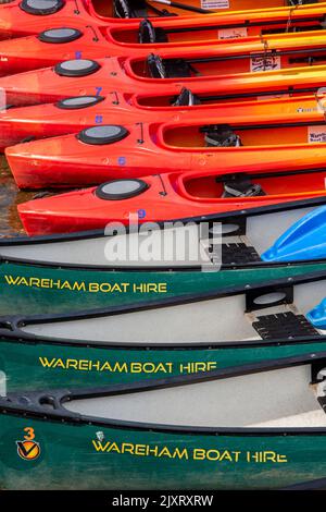 abstract colourful close up of canoes and kayaks on the quay at wareham in dorset, colourful canoes and kayaks, abstract image of boats, patterns. Stock Photo