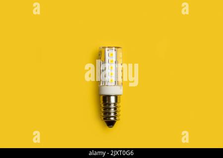 Led lightbulb on a yellow background in a close up view Stock Photo