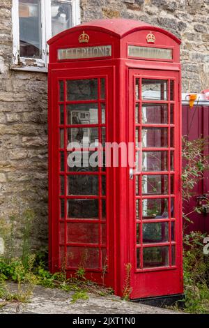 working example of a red telephone box in corfe castle on the isle of purbeck in dorset, telecommuncations box in typical red paint, gpo phone box. Stock Photo