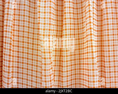 Close up of fabric folds of orange checkered pattern Stock Photo