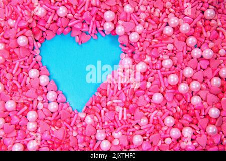 Full frame pink heart sprinkles and a turquoise heart shape, copy space Stock Photo