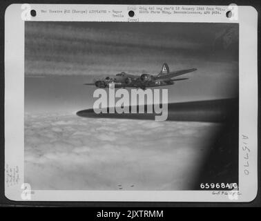 Against A Background Of Vapor Trails Etched By Proceding Heavy Bombers, The Boeing B-17 'Flying Fortress' 'Bacta Th' Sac' Of The 381St Bomb Group Heads Toward Its Objective, Somewhere In Europe. Stock Photo