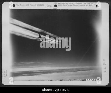 A Boeing B-17 'Flying Fortress' Of The 381St Bomb Group Is Pictured Against A Backdrop Of Vapor Trails Left By A Preceding Formation, En Route To Bomb Nazi Installations, Somewhere In Europe. Far In The Distance, Barely Visible, Is Another Group Of Plane Stock Photo