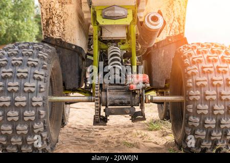 Rear view of the ATV standing on sandy ground Stock Photo - Alamy