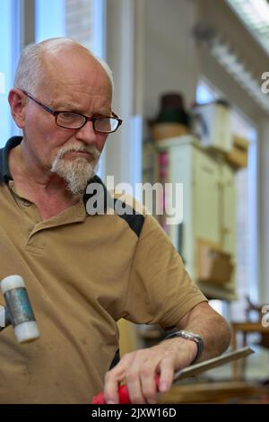 Carpenter Working With Hammer And Chisel In His Workshop. Russikon, Zurich Oberland, Switzerland Stock Photo