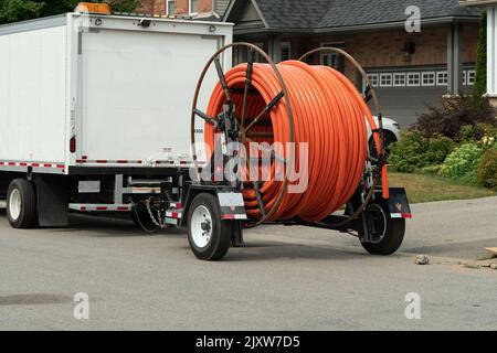 Red plastic pipe for fiber optic cable on trailer reel Stock Photo