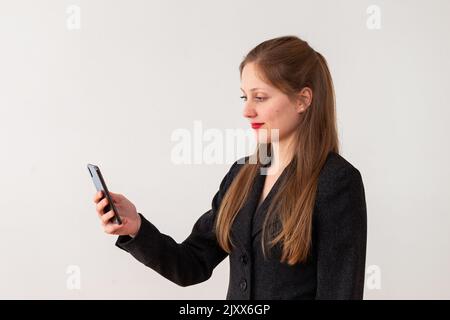 Young Caucasian woman looking at her phone from side view Stock Photo