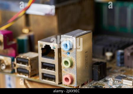 Old motherboard covered in dust and dirt. Close-up. Stock Photo