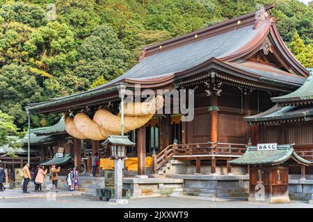 kyushu, japan - december 08 2021: Japanese faithful queueing in family for praying in front of the Miyajidake Shrine adorned with an impressive shinto Stock Photo