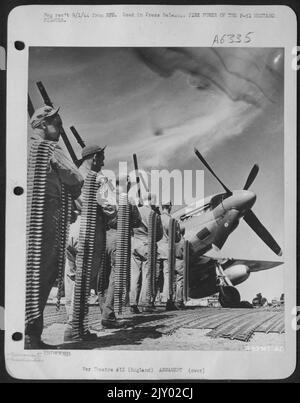FIRE POWER OF THE P-51 MUSTANG FIGHTER. These are the six .50 calibre machine guns used in the new U.S. Army 8th Air force P-51 Mustang fighters. The cartridge belts being carried represent the amount used by only ONE gun on a flight. 36 men would Stock Photo