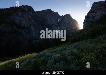 The sun setting behind the mouth of Death Canyon in the Teton Mountains. Grand Teton National Park, Wyoming Stock Photo