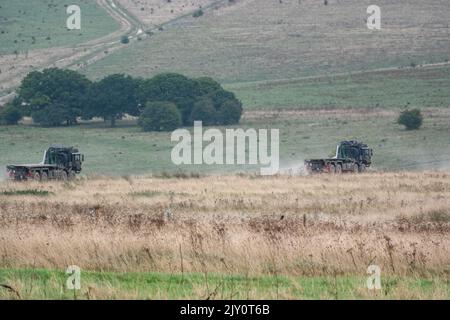 British army MAN SV HX77 8x8 EPLS Heavy Utility Trucks in action on a military exercise Stock Photo