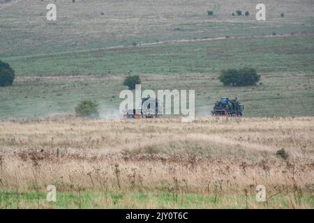 British army MAN SV HX77 8x8 EPLS Heavy Utility Trucks in action on a military exercise Stock Photo