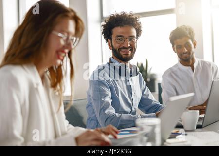Group of happy coworkers working together analyzing the charts in modern office Stock Photo