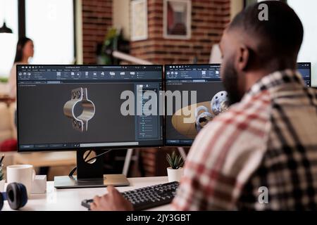 African american developer setting up gears model on manufacturing software, developing engine product for technical industry innovation. Creating turbine design with industrial cad science. Stock Photo