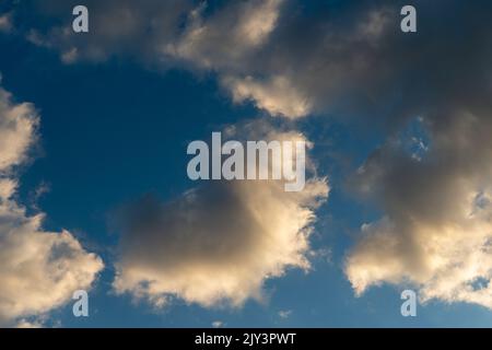 White and dark, fluffy clouds in blue sky. Background from clouds. Stock Photo