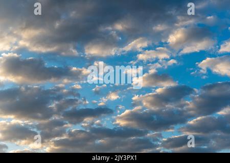White and dark, fluffy clouds in blue sky. Background from clouds. Stock Photo