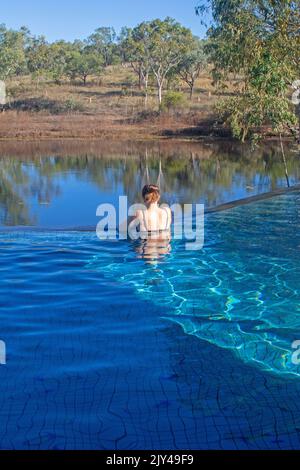 A woman in an infinity swimming pool at Farm Lands of Love agritourismo ...