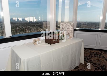 Reception venue has table set up for guests to fill out well wishes cards along with a beautiful window view of the city. Stock Photo