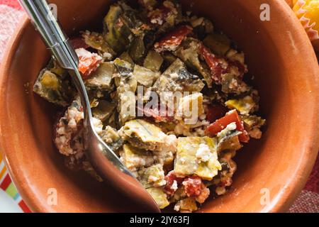 eggplant and tomato salad with olive oil and garlic top view in clay plate or pot Stock Photo