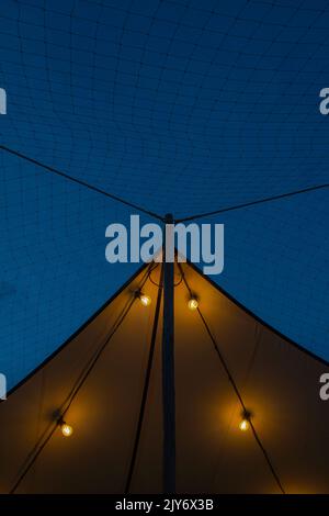 Outdoor string light bulbs against blue sky Stock Photo