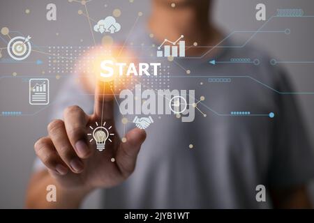 On a modern virtual interface, there is a startup concept with an icon business and a network connection. Man touches on the start. Stock Photo