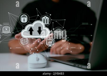 A man uses a laptop with a cloud computing diagram shown on hand. Cloud computing networking and internet service principles for data storage. Stock Photo