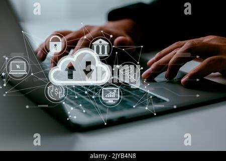 On a man's laptop is a cloud computing schematic. Cloud computing, data storage, and internet service ideas. Stock Photo