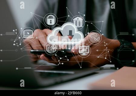A man uses a laptop with a cloud computing diagram on it. Concepts of data storage, networking, and internet service for cloud computing. Stock Photo