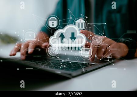A man uses a laptop that has a diagram of cloud computing on it. Concepts of data storage, networking, and internet service for cloud technology. Stock Photo