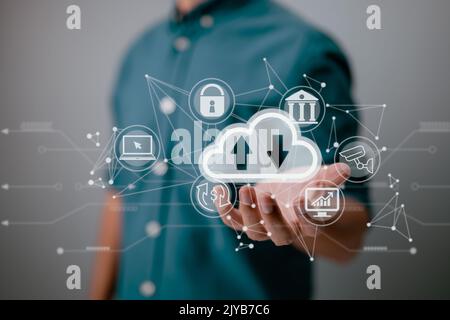 A man holding a cloud computing diagram displayed on the screen. Concepts of cloud computing, data storage, networking, and internet services. Stock Photo