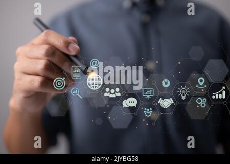 IoT, digital marketing, and global business. Business strategy concept for the Internet of Things. With technical icons, a businessman touches on the Stock Photo