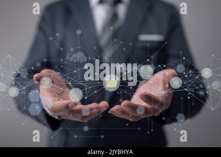 DMS for Document Management System. A businessman has a folder and a document symbol in his hands. Archiving, finding, and managing business files and Stock Photo