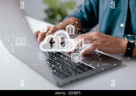 A man uses a laptop with a cloud computing diagram shown on hand. Cloud technology Data storage networking and internet service concepts. Stock Photo