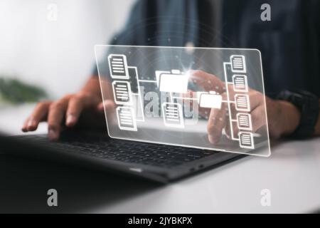 Document management system and online database. A businessman uses a laptop, Document Management System, and Automation software to archive and handle Stock Photo