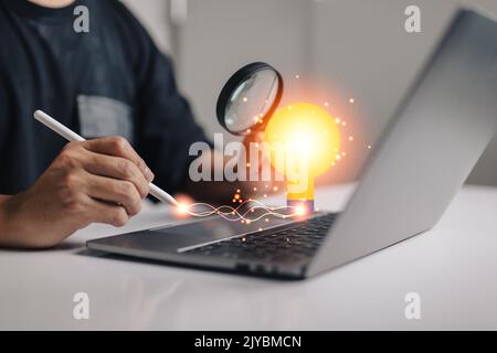 business insights, business people writing with ideas, discover business outlook concepts, business people looking at light bulbs with a magnifying gl Stock Photo
