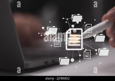 To successfully handle files, a businessman uses a contemporary computer with a Document Management System (DMS), a virtual online documentation datab Stock Photo